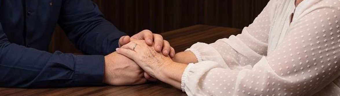 Mãos dadas sobre a mesa, durante uma conversa